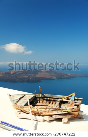Old boat on the roof of a private villa in Firostefani, Santorini, with a perfect view of the volcanic island