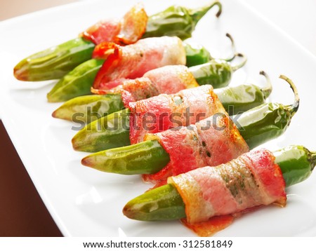 Grilled jalapenos, wrapped in bacon. Tilted view.