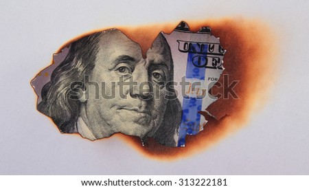 burning dollar bill as a symbol of inflation and the financial crisis