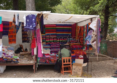 Mayan Woman in a Market Booth with Colorful Textiles
