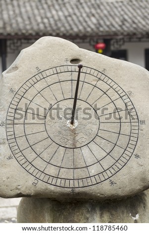 ancient sun dial to keep track of time in China with temple in background
