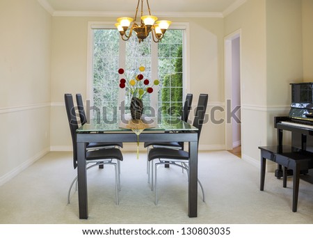 Horizontal photo of family formal dining room with daylight coming through large windows in background