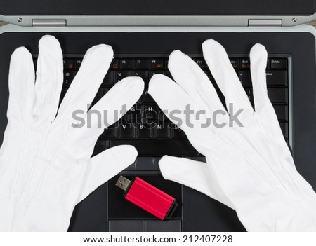Closeup top view of a white gloves and USB Thumb drive on top of computer keyboard