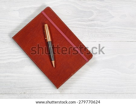 Image of executive notepad with pen on rustic white wood with plenty of copy space.