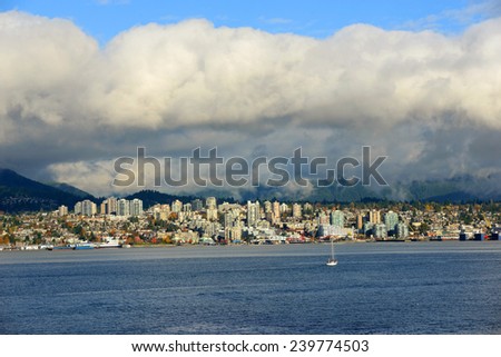 North Vancouver city skyline across Vancouver Harbour in a cloudy day, Vancouver, British Columbia, Canada.