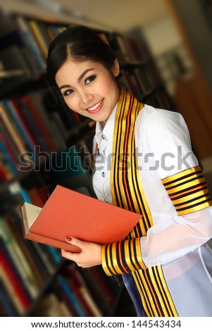 Asian graduate girls happily and reading at the library