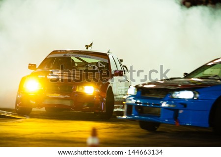 NONTHABURI THAILAND-JUNE 30 : Battle lap of two drift drivers at night time in D1 Grand Prix Series Thailand Professional Drift on June 30, 2013 in Nonthaburi, Thailand.