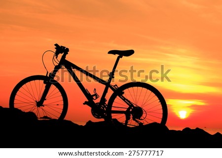 Silhouette of mountain bike over the sunrise in the morning.