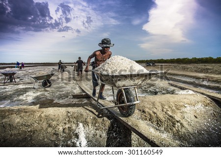 SAMUT-SAKHON, JUNE 5 : Unidentify Thai's labor are moving mound of salt into a warehouse for sell at salt farm on June 5, 2015 in Samut Sakhon. Salt farm is agriculture in seaside town in  Thailand.