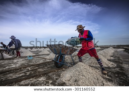 SAMUT-SAKHON, JUNE 5 : Unidentify Thai's labor are moving mound of salt into a warehouse for sell at salt farm on June 5, 2015 in Samut Sakhon. Salt farm is agriculture in seaside town in  Thailand.