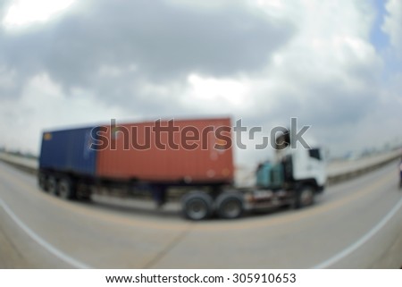 Blurry image of Container truck on free way. Photograph by fisheyes lens.