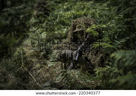 Special forces soldier during change of ammunition clip.