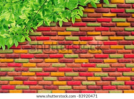 Leaves on a colored brick wall. Useful as background for design-works.