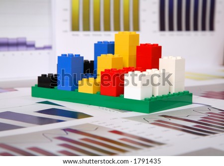 Bar chart built out of coloured toy building block on a paper chart background