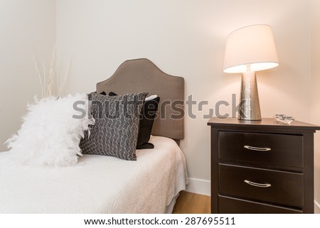 Luxury bedroom. Contemporary design with reclaimed wood bedside tables and lamp. Nice and cozy accommodations. Hotel or resort room.