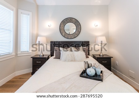 Luxury bedroom. Contemporary design with reclaimed wood bedside tables and lamp. Nice and cozy accommodations. Hotel or resort room.
