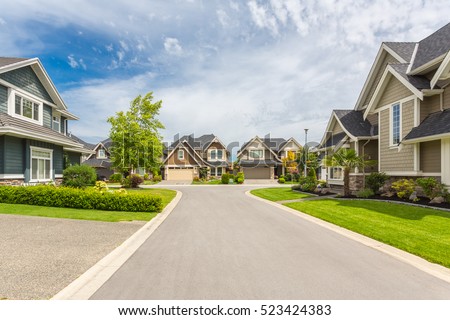 Nicely trimmed and manicured garden in front of a luxury house on a sunny summer day. Street of houses in the suburbs of Canada. Stock foto © 