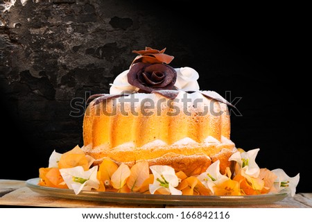 bundt cake on plate decorated with chocolate flowers and a wall as background