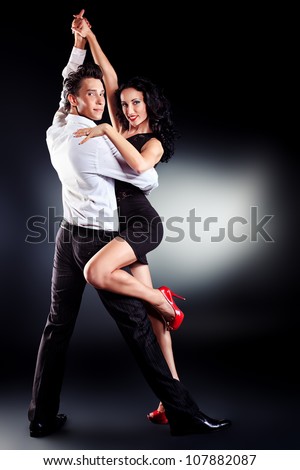 Beautiful couple of professional artists dancing passionate dance.