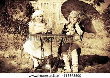 Two little girls having a rest at a park. Retro style.