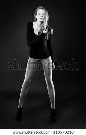 Full length portrait of an attractive young woman in fitting clothing posing at studio.