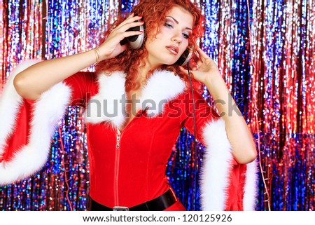 Christmas DJ girl dancing in headphones. Disco lights in the background.