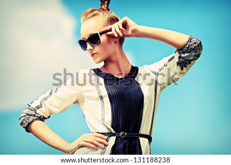 Fashion woman posing over blue sky.