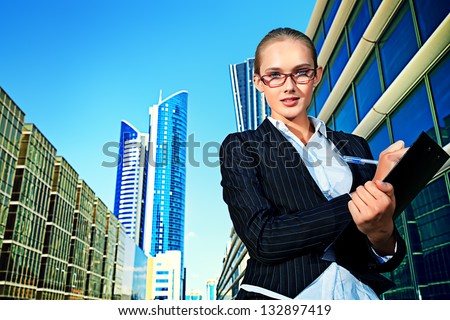 Beautiful businesswoman standing on the street of the big city.