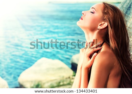 Romantic beautiful woman sunbathing on a seaside.