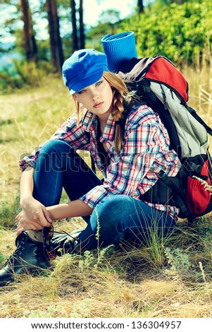 Beautiful girl tourist having a rest on a trekking trail.