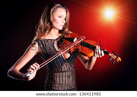 Elegant  young woman playing her violin with expression.
