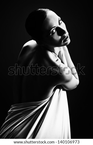 Art portrait of a beautiful  woman back over black background.