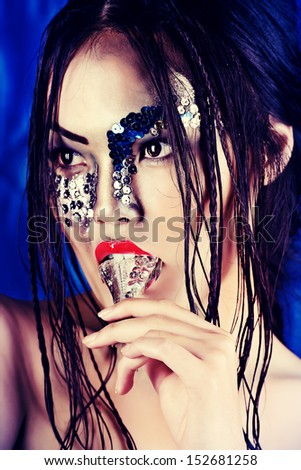 Portrait of an asian model with fantasy make-up. Black background.