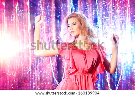 Modern girl dancing at the party. Disco lights.