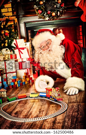 Santa Claus playing with toys under the Christmas tree.