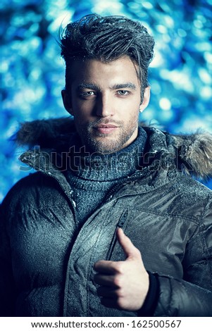 Portrait of a handsome man dressed in winter clothes, covered with frost.