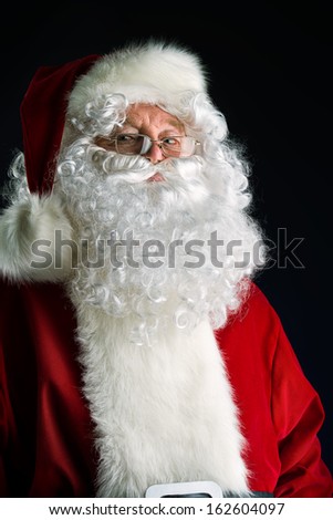 Portrait of a traditional Santa Claus. Over dark background. Christmas.