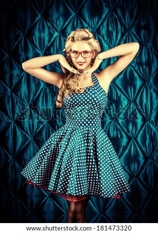 Gorgeous pin-up woman with retro hairstyle and make-up wearing red spectacles.