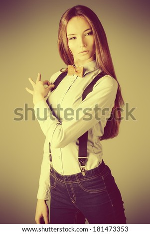Elegant girl model poses in blouse and bow tie. Fashion shot.