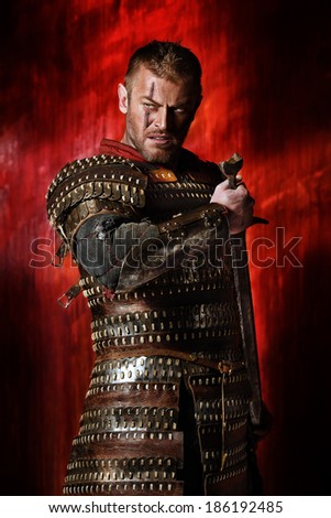 Portrait of a courageous ancient warrior in armor with sword.