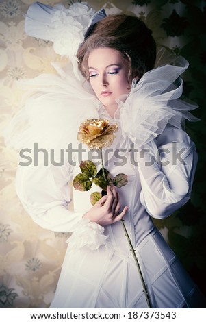 Beautiful fashion model in the refined white dress and elegant hat. Vintage style. Art project.