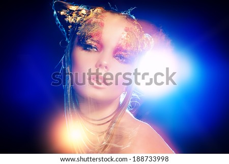 Art project: beautiful woman with golden make-up. Jewelry, make-up. Fashion. Light effects.