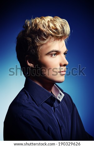 Portrait of a handsome young man posing at studio. Profile.