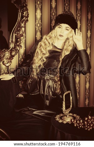 Gorgeous fashion model with magnificent blonde hair in a rich historical costume. Fur clothing. Vintage. Luxury style.