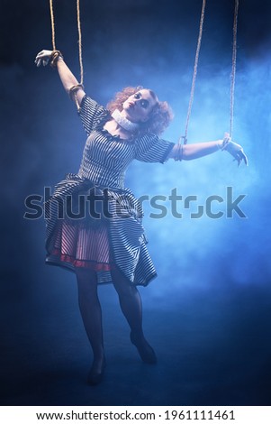 Puppet theater and circus. The actress plays a doll on strings at a performance in a puppet theater. Full length portrait in vintage style.