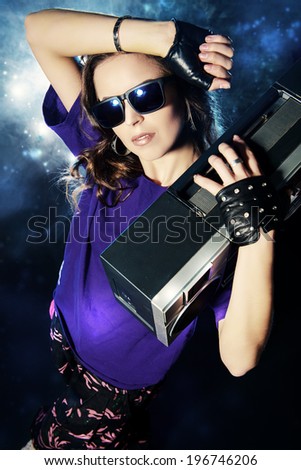 Portrait of a modern girl with tape recorder over grunge background. Street urban style.