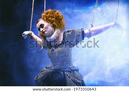 Circus and puppet theater. The actress plays a doll on strings at a performance in a puppet theater. A portrait in retro style.