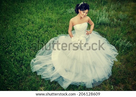 Beautiful elegant asian bride in a summer park. Wedding dress and accessories.