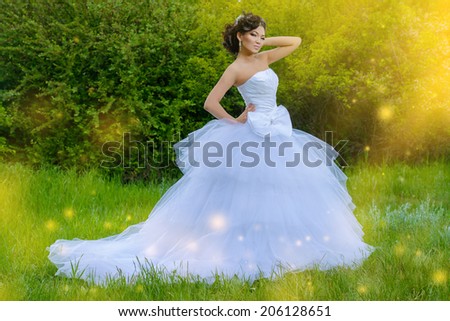 Beautiful elegant asian bride in a summer park. Wedding dress and accessories.