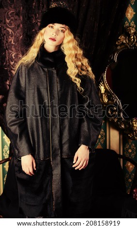 Gorgeous fashion model with magnificent blonde hair in a rich historical costume. Fur clothing. Vintage. Luxury style.